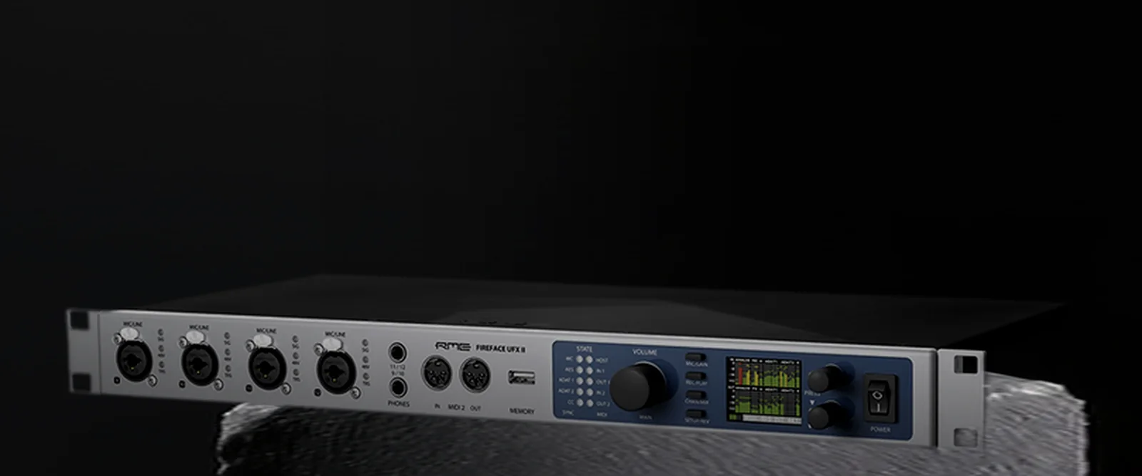A rack-mount audio interface with a colour level-meter display, lit hard against a dark void.